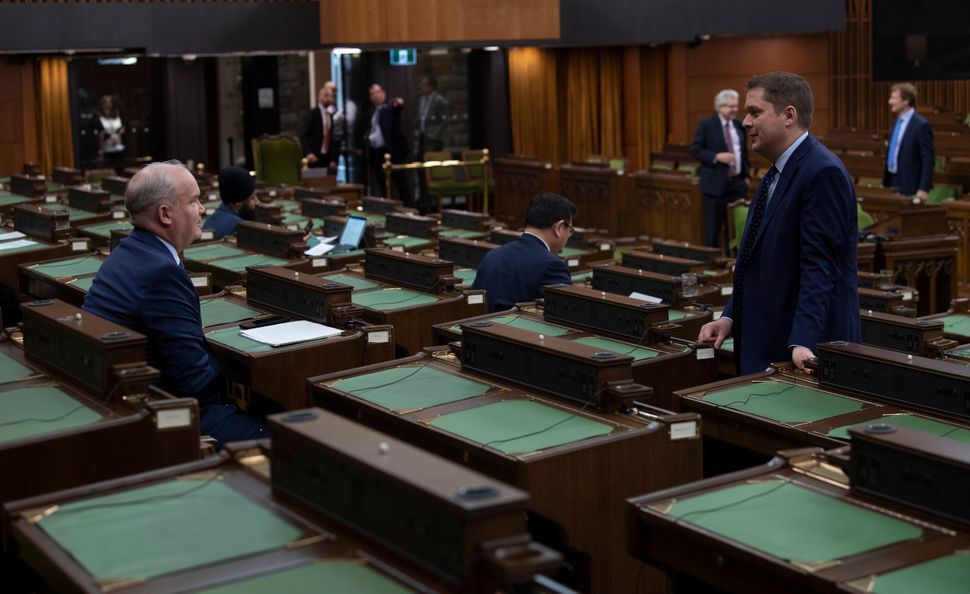 Conservative leader Andrew Scheer speaks with Conservative MP Erin O'Toole as they wait for the COVID-19 committee committee in the House of Commons on April 29, 2020 in Ottawa.
