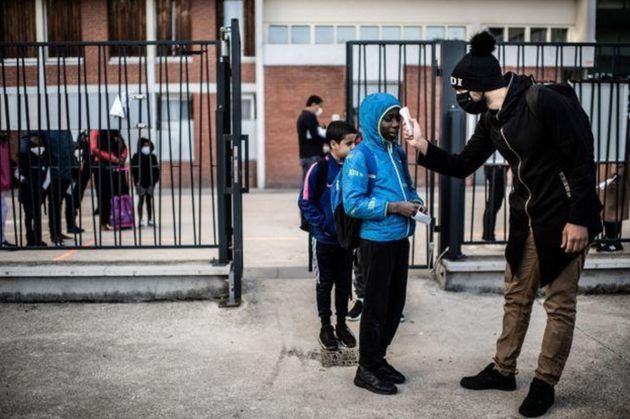 Alunos passam por medição de temperatura antes de entrar na escola Saint-Exupery em La Courneuve, subúrbio...