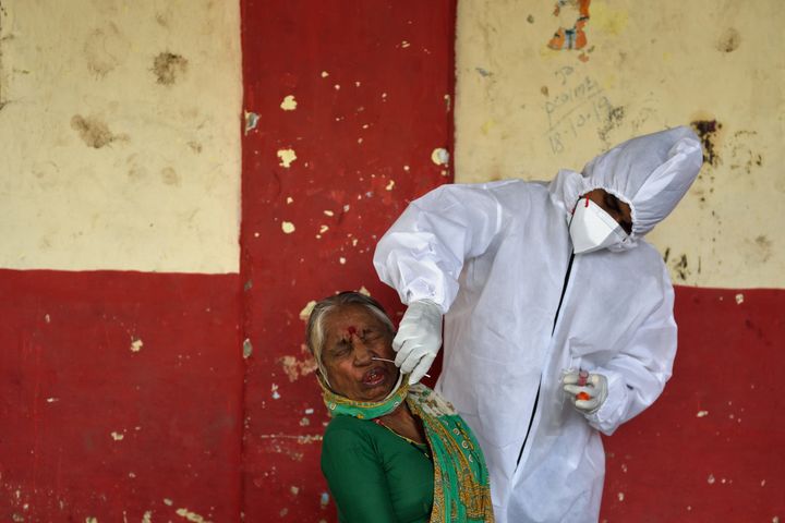 : A BMC health care worker collect swab sample of a resident in Chembur slums during Covid-19 pandemic, on August 19, 2020 in Mumbai, India