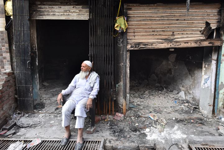 An elderly man seated outside shops burnt in the riots across North East Delhi, at Shiv Vihar, on March 15, 2020 in New Delhi