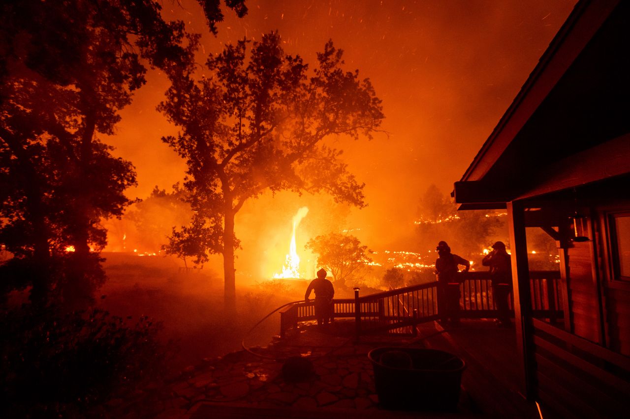Firefighters watch flames from the LNU Lightning Complex fires approach a home in the Berryessa Estates neighbourhood of unincorporated Napa County, California.