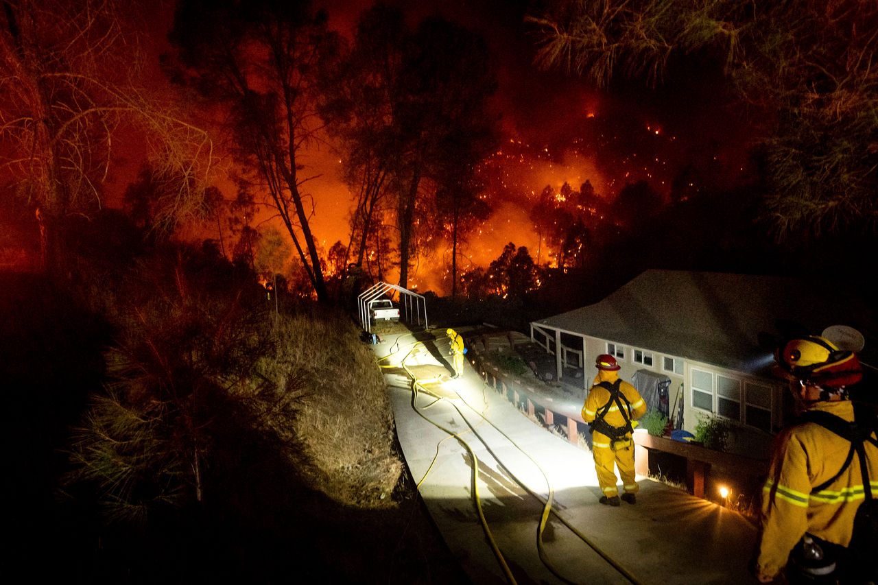 Firefighters protect a home in the Berryessa Estates neighborhood of unincorporated Napa County.