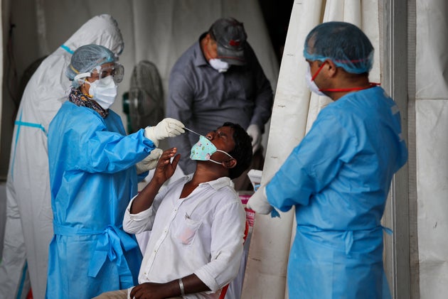 Health workers conduct COVID-19 antigen tests for migrant workers in New Delhi, India, Aug. 18,