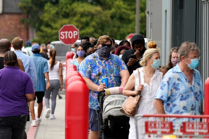 People line up to enter retail chain Costco to buy provisions in New Orleans on Sunday in advance of Hurricane Marco.