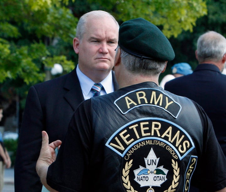 Erin O'Toole speaks with a veteran after taking part in the National Peacekeepers' Day ceremony in Ottawa on Aug. 9, 2015.