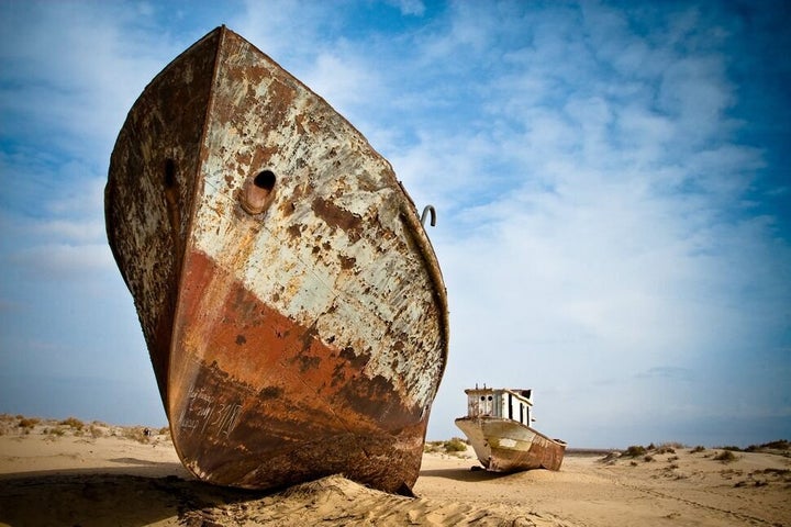 "Bateaux succombant à la rouille proches des bords de la mer d'Aral, entre le Kazakhstan et l'Ouzbékistan. Il y eut un temps où ce fut le quatrième plus grand lac au monde mais le drainage intensif de l'eau pour irriguer les champs de coton a eu raison de plus de 90 % de la surface initiale de la mer d'Aral."