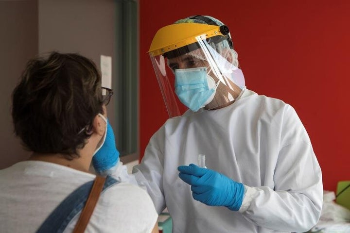 Un sanitario toma la temperatura a una paciente