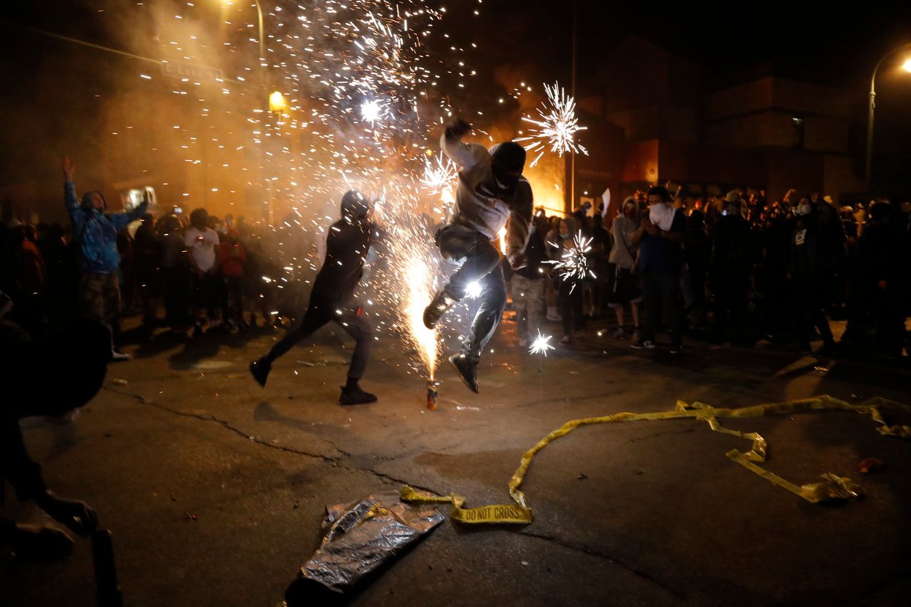 Protesters set off fireworks as a fire burns at the Minneapolis police 3rd Precinct building, May 28, following the police killing of George Floyd.