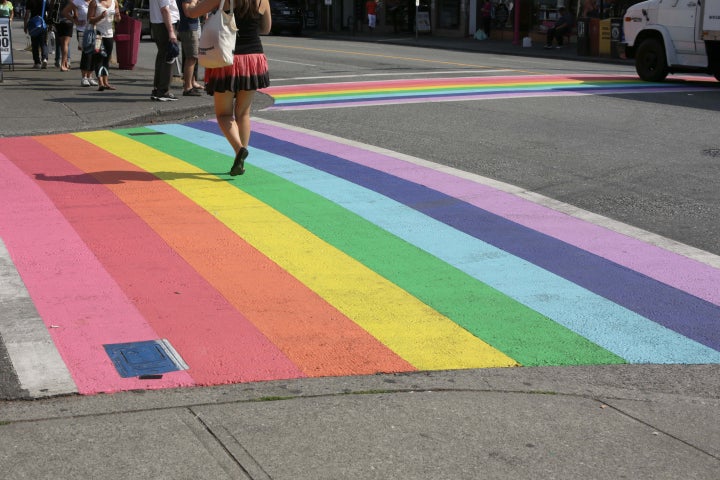 A pedestrian crosses the rainbow crosswalk at the intersection of Davie and Bute Streets in Vancouver's west end. 