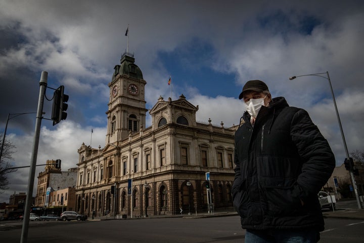 A man wearing a mask walks across Sturt Street in Ballarat on August 21, 2020 in Ballarat, Australia. COVID-19 testing in Ballarat has increased as health authorities work to avoid the spread of coronavirus in regional Victoria.