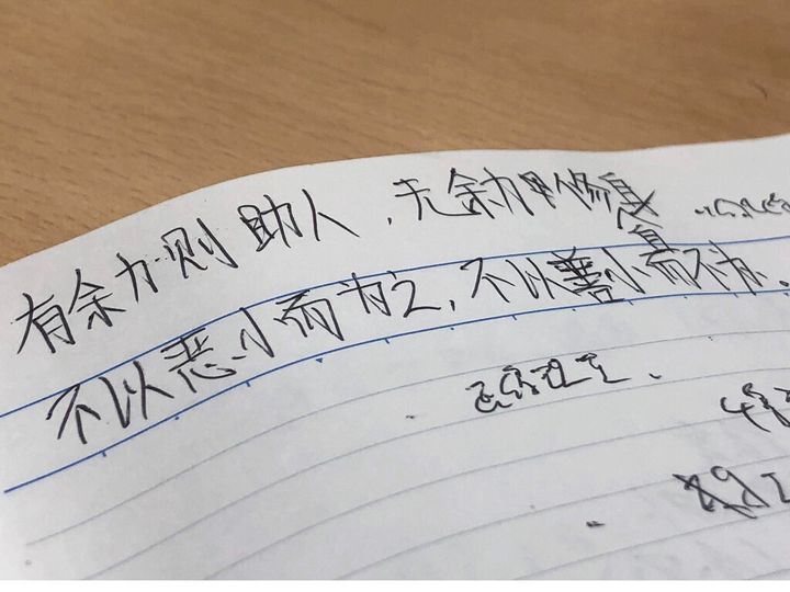 郭さんが記者のノートに書いた文字。「余力ある時は人を助け、余力なき時は修練する」という意味がある