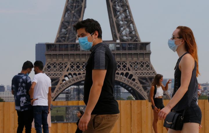 People wearing masks to prevent the spread of coronavirus walk at Trocadero plaza near Eiffel Tower in Paris, Saturday, August 8.