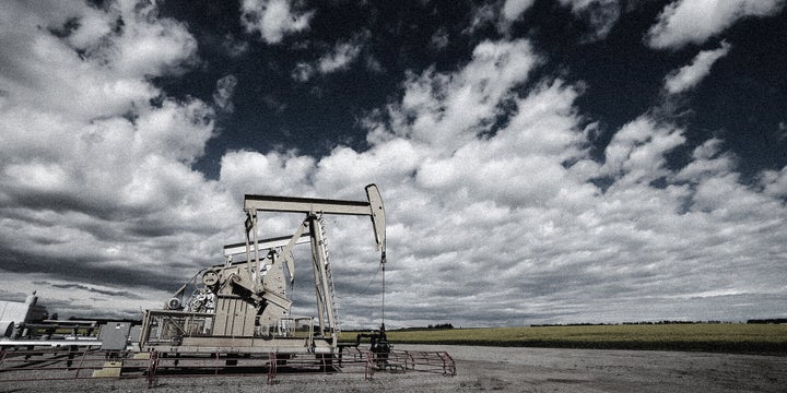 Pump jacks draw oil out of the ground near a canola field in Olds, Alta., on July 16, 2020.