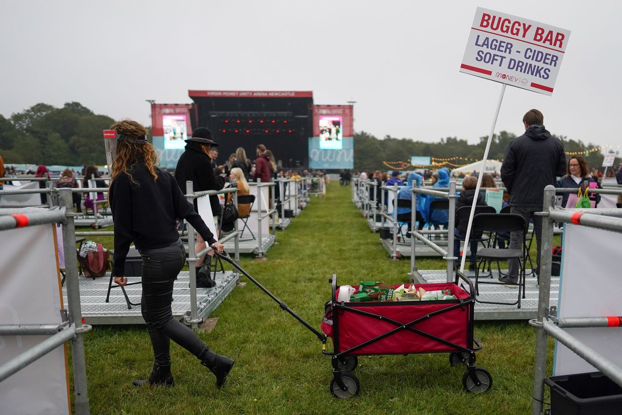 An employee wheels a mobile drink trolley between socially distanced enclosures ahead of Sam Fender performing at the Virgin Money Unity Arena on Aug. 13 in Newcastle upon Tyne, England. Sam Fender is the first to perform at the socially distanced music venue. 