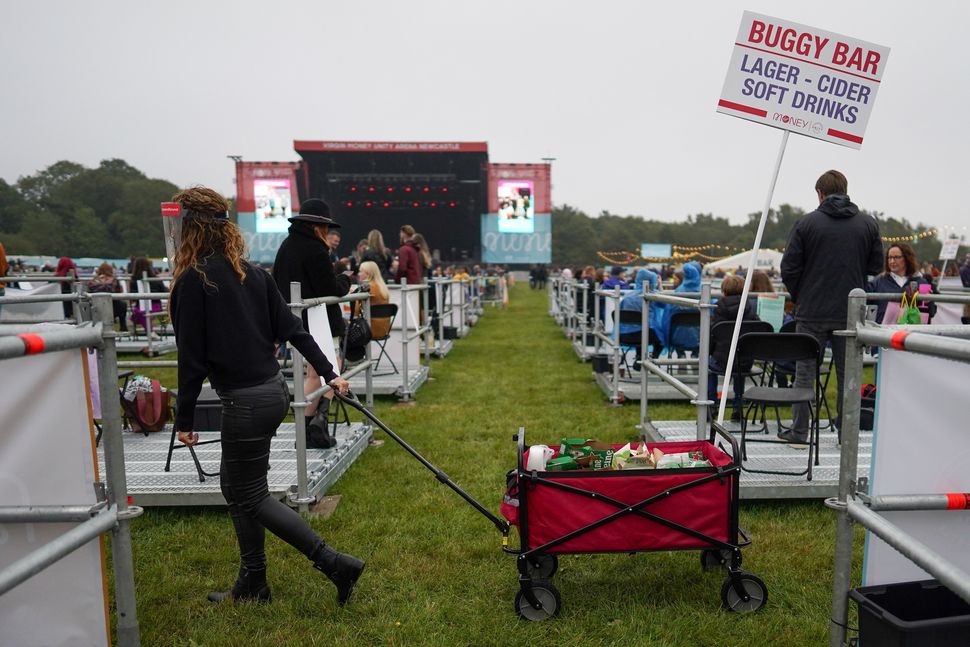 An employee wheels a mobile drink trolley between socially distanced enclosures ahead of Sam Fender performing at the Virgin 
