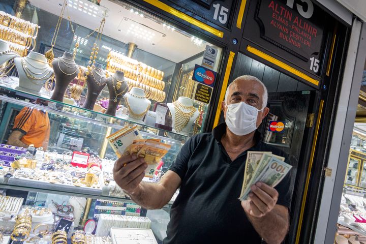 ANKARA, TURKEY - AUGUST 13 2020: Ένας άνδρας μπροστά σε κοσμηματοπωλείο κρατά ξένα χαρτονομίσματα, καθώς η λίρα έχει πάρει έναν ατελείωτο κατήφορο, παρά την προσπάθεια της κεντρικής τράπεζας της Τουρκίας να αμυνθεί ρίχνοντας στην αγορά δισεκατομμύρια λίρες για την ενίσχυση της ρευστότητας. PHOTOGRAPH BY Feature China / Barcroft Studios / Future Publishing (Photo credit should read Feature China/Barcroft Media via Getty Images)