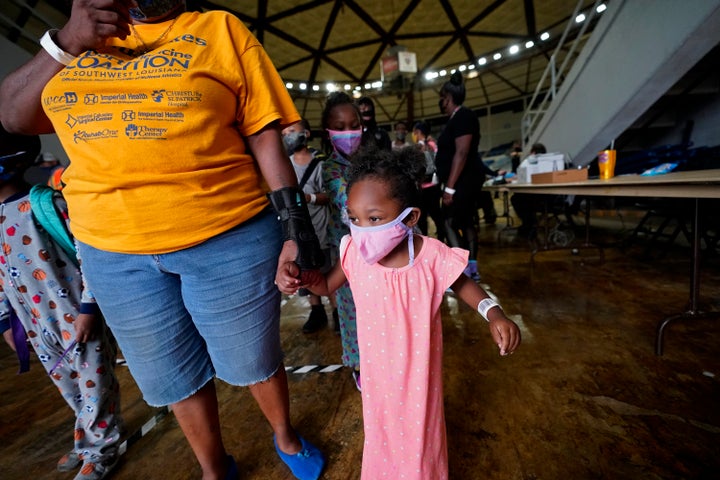 Victoria Nelson walks with her daughter Autum Nelson, 2, to board a bus to evacuate Lake Charles, La., Wednesday, Aug. 26, 2020, ahead of Hurricane Laura. (AP Photo/Gerald Herbert)