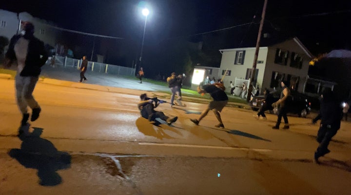 Men scuffle during a protest Tuesday following the police shooting of Jacob Blake, a Black man, in Kenosha, Wisconsin, in this still image obtained from a social media video.