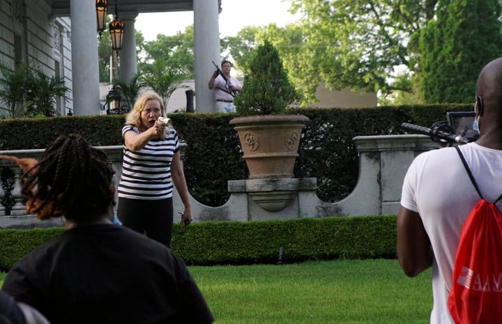 Patricia McCloskey and her husband Mark McCloskey draw their firearms on protesters as they enter their neighborhood in St. Louis, Missouri, on June 28, 2020.