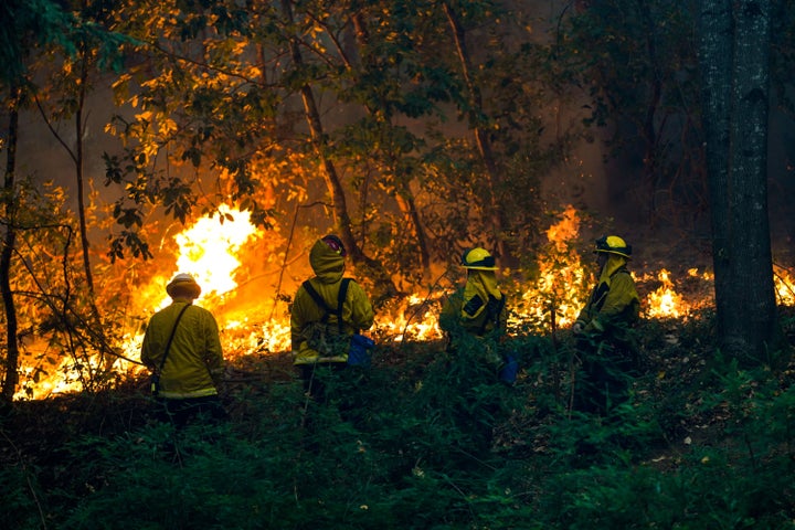Firefighters battling a blaze near a house during the CZU Lightning complex fire in Boulder Creek, California, on Sunday.