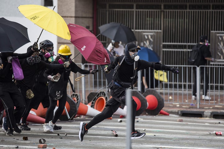 香港・新界地区で、雨傘や火炎瓶を手に警察に抵抗するデモ隊（中国・香港=2019年10月1日）