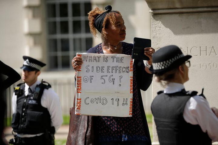 A woman holds up a placard at a coronavirus anti-lockdown, anti-vaccine, anti-5G and pro-freedom protest near Scotland Yard in London on May 2 2020.