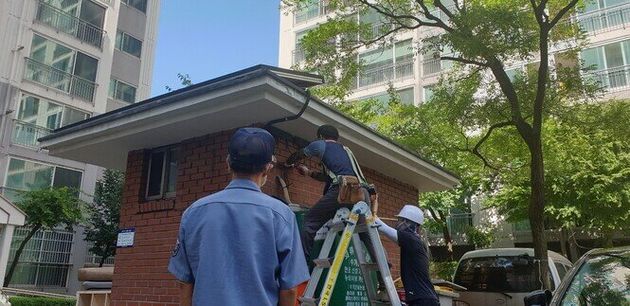 지난 25일 설비업체 직원들이 대전 대덕구 한 아파트 경비실에 미니태양광 시설을 설치하는 모습을 이 아파트 경비원이 바라보고