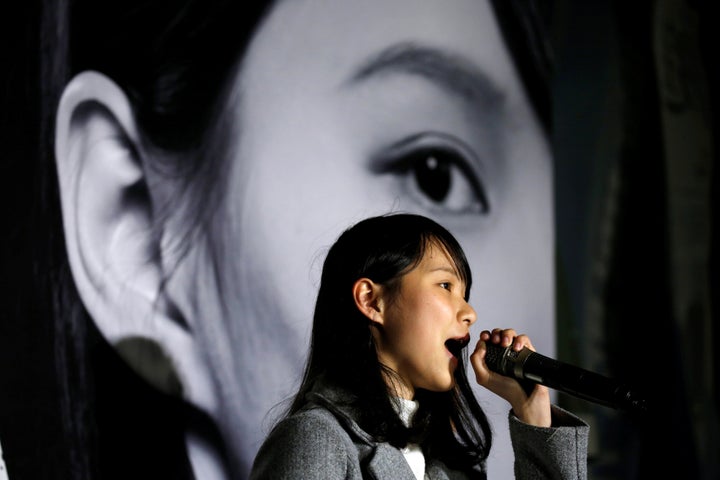 Pro-democracy activist Agnes Chow, 21, attends a rally in front of her portrait after she was banned from running in a by-election, in Hong Kong, China January 28, 2018. REUTERS/Bobby Yip