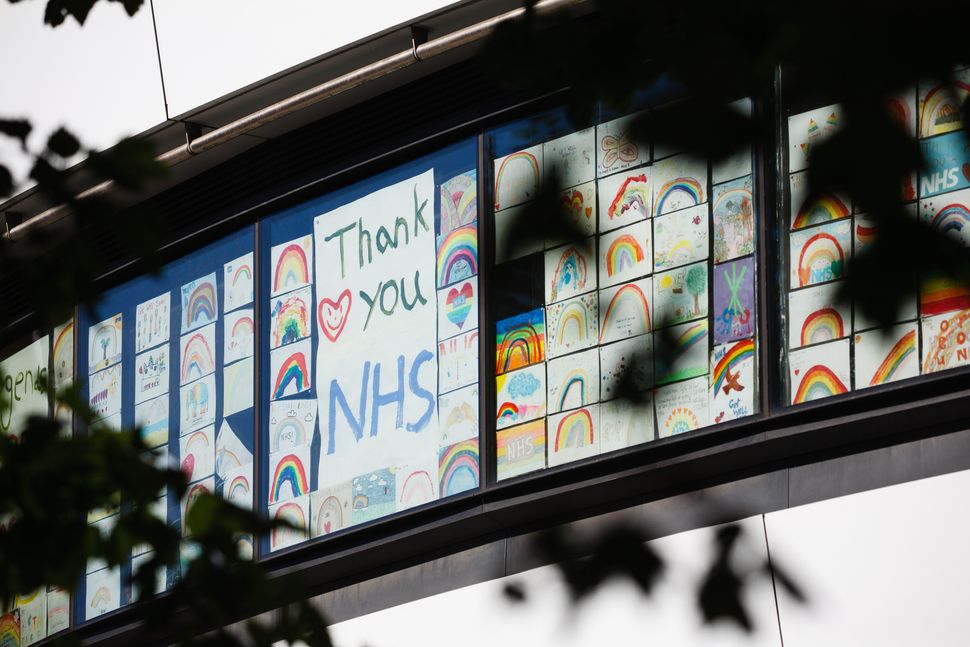 Rainbow drawings and messages of support for the NHS cover windows of a college building opposite St Thomas' Hospital in London