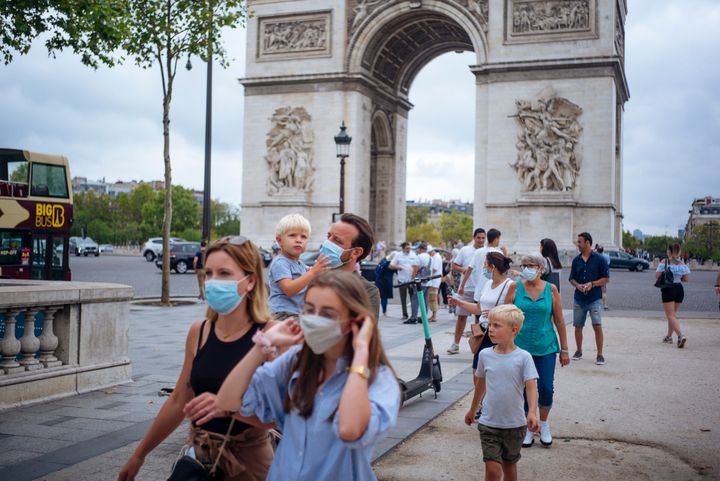 Εικόνα αρχείου (15 Αυγούστου 2020). Μία οικογένεια τουριστών που φορούν μάσκες μπροστά στην Αψίδα του Θριάμβου στο Παρίσι. Ο κορονοϊός «καλπάζει στο 20% των περιφερειών της Γαλλίας και οι μάσκες θα είναι πλέον υποχρεωτικές για όλους στο Παρίσι. Ωστόσο, η κυβέρνηση είναι αποφασισμένη να ανοίξει τα σχολεία την ερχόμενη εβδομάδα, να επιστρέψουν στις εργασίες τους οι Γάλλοι και να αρχίσει ο ποδηλατικός γύρος της Γαλλίας την Κυριακή. (AP Photo/Kamil Zihnioglu, File)
