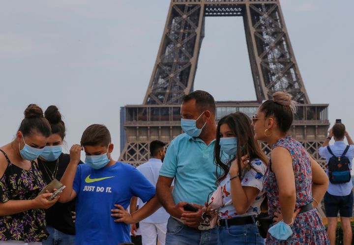 A Italian tourist family wearing a masks to prevent the spread of COVID-19 gather at Trocadero plaza near Eiffel Tower in Paris, Saturday, Aug 8, 2020. The French health agency said yesterday indicators show an increasingly active circulation of the virus, ''especially among young adults,'' and appealed for respect of safety measures ''and good sense.''(AP Photo/Michel Euler)