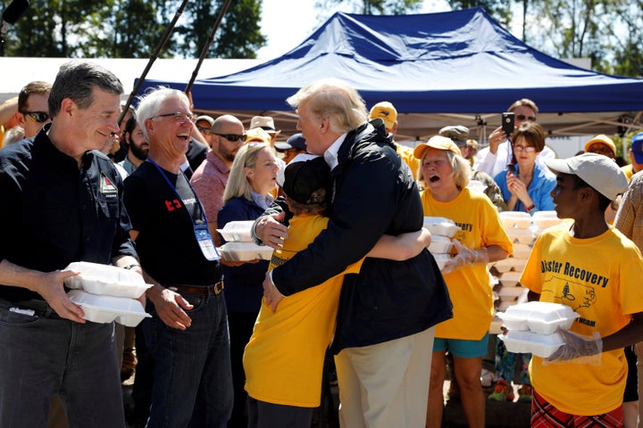 President Donald Trump embraces a boy at a distribution center in New Bern, North Carolina, while participating in a tour of Hurricane Florence recovery efforts, Sept. 19, 2018.