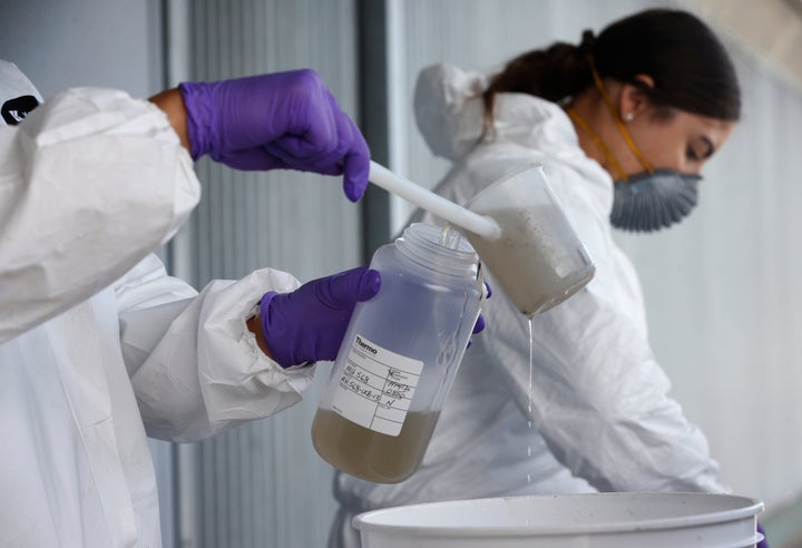 Wastewater control inspectors Zach Wu and Gabriela Esparza (right) transfer sewer water into bottles that will be sent labs for testing in Oakland, California, on July 14.