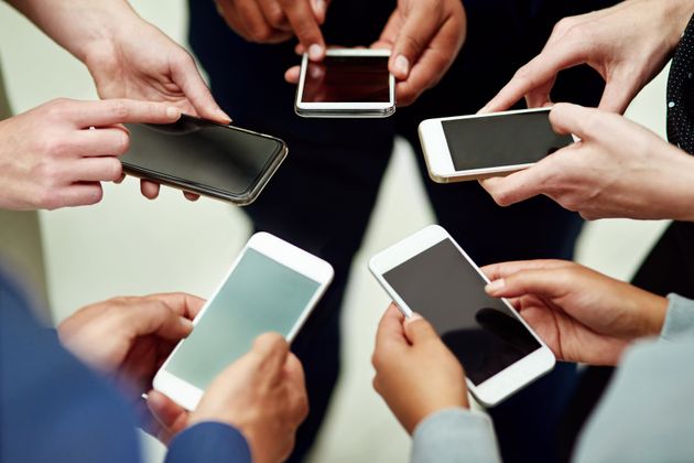 Cropped shot of a group of unidentifiable businesspeople using their smartphones in a