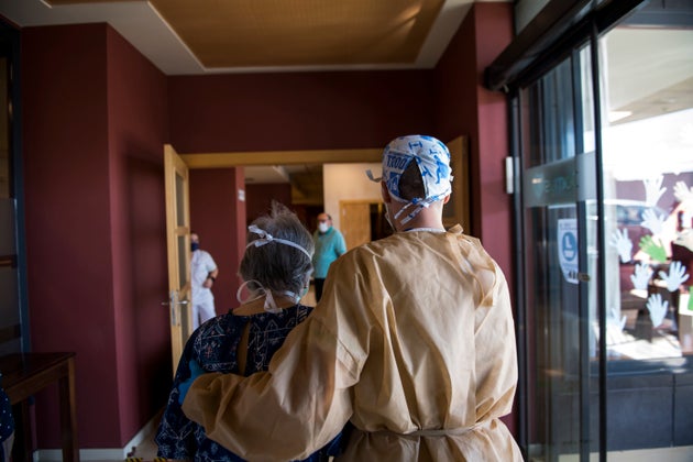 Un enfermero acompaña a una mujer mayor a la zona de visitas en una residencia de Granada, el 1 de junio...