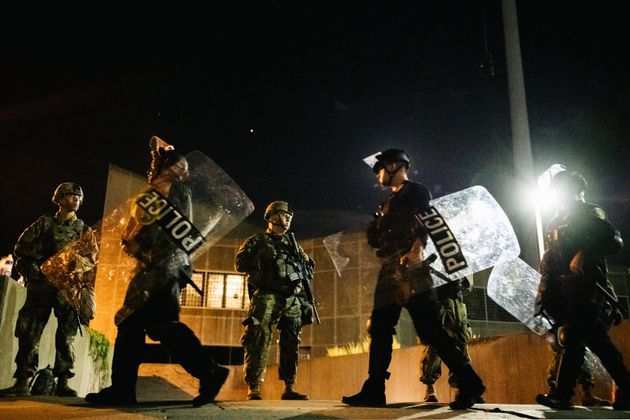 National Guard troops stand guard inside of a fenced area in Kenosha, Wisconsin. 