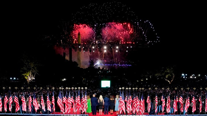President Donald Trump, first lady Melania Trump and family members stand to watch fireworks after the president delivered hi