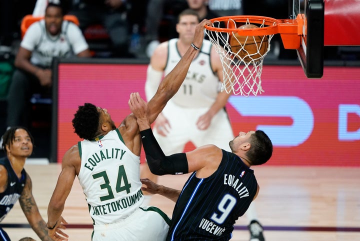 Milwaukee Bucks' Giannis Antetokounmpo dunks the ball over Orlando Magic's Nikola Vucevic during the second half of an NBA basketball game on Aug. 24, 2020, in Lake Buena Vista, Florida. 