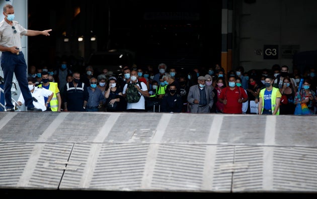 Viajeros con mascarillas aguardan el desembarco de un transbordador en el puerto de El Pireo, Grecia, 20 de agosto de 2020. (AP Foto/Thanassis Stavrakis)
