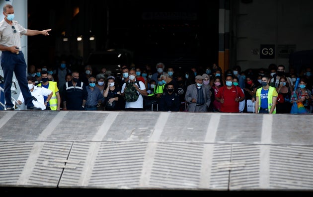 Viajeros con mascarillas aguardan el desembarco de un transbordador en el puerto de El Pireo, Grecia, 20 de agosto de 2020.   (AP Foto/Thanassis Stavrakis)