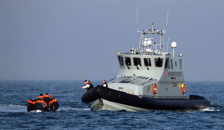 A Border Force vessel assist a group of people thought to be migrants on board from their inflatable dinghy in the Channel on August 10 2020.