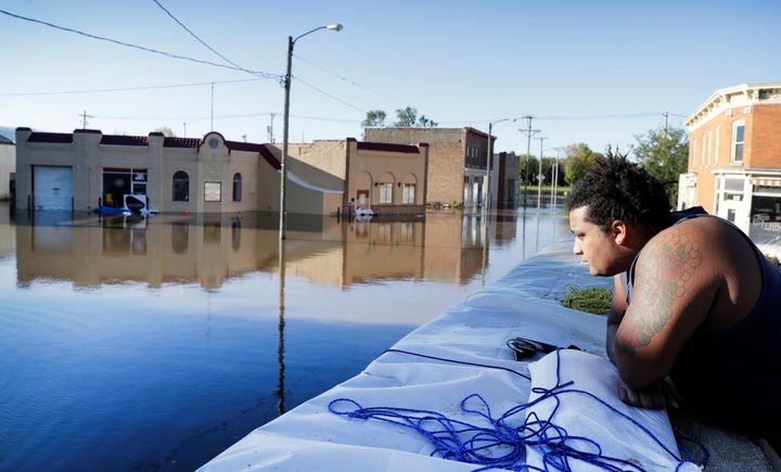 Cory Harrison stands on a floodwall as he looks over businesses flooded by the Cedar River on Sept. 27, 2016, in Cedar Rapids. The city hastily erected a 9.8-mile system of Hesco barriers and earthen berms, which helped hold back the river.