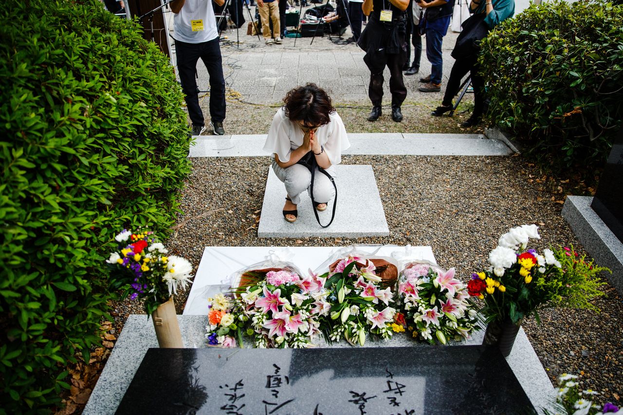 朝鮮人犠牲者追悼碑の前で手を合わせる女性