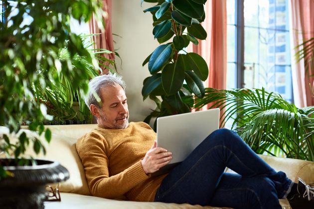 Man working in living room with laptop