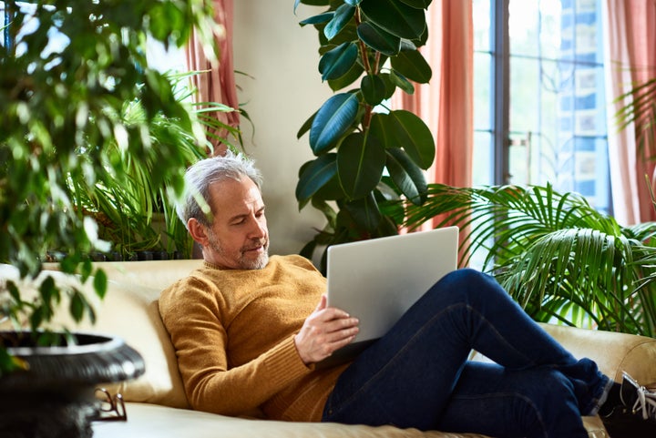 Man working in living room with laptop