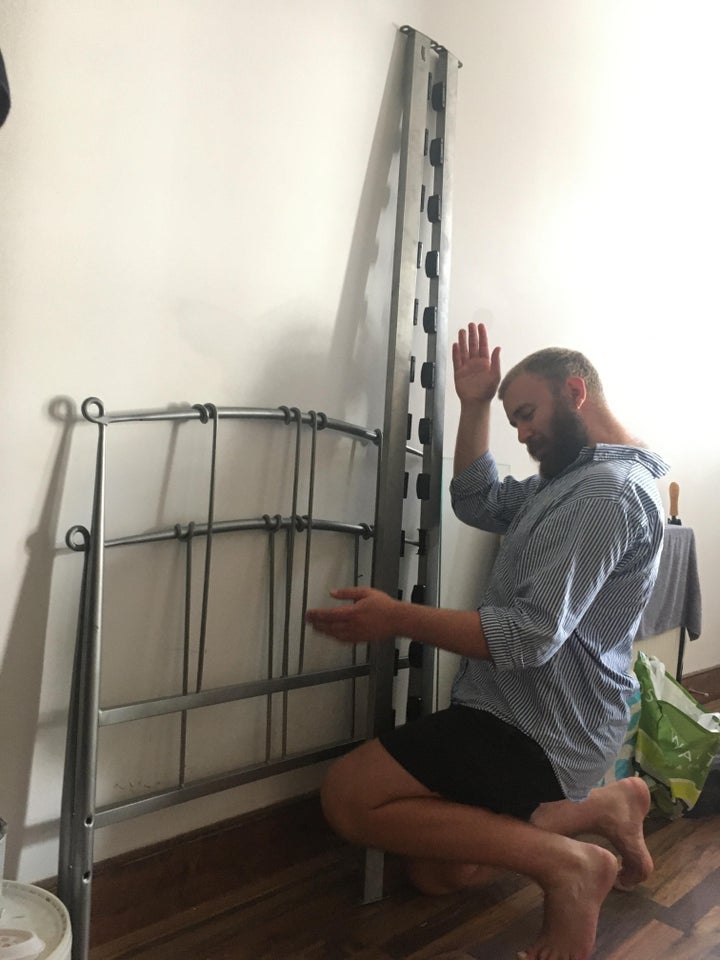 Sam modelling beside a metal bed frame. 