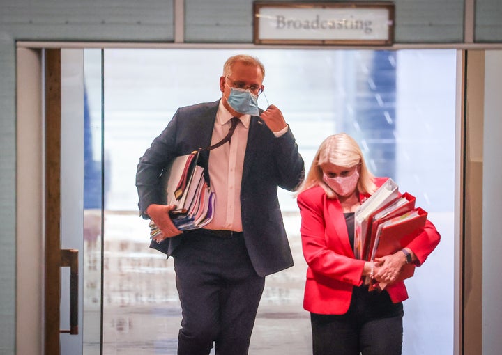 Australian Prime Minister Scott Morrison removes his face mask as he enters the House of Representatives for Question Time at Parliament House on September 2, 2020 in Canberra, Australia.