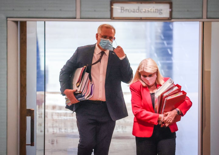 Australian Prime Minister Scott Morrison removes his face mask as he enters the House of Representatives for Question Time at Parliament House on September 2, 2020 in Canberra, Australia. 