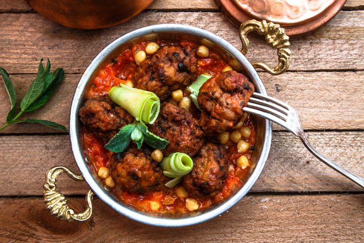 Arabian meatballs kofte with chickpeas, spicy tomato sauce and mint.