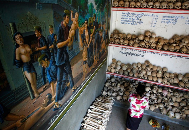 A resident prays in front of skulls at a "Killing Fields" memorial in Batey district in Kampong Cham province.